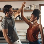 a man and a woman dance in well lit kitchen